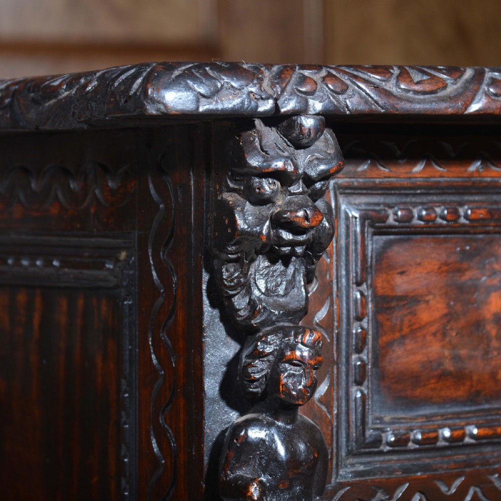 A dark carved walnut Italian Renaissance style chest of drawers featuring small carved figural pilasters and turned bun feet. View IX