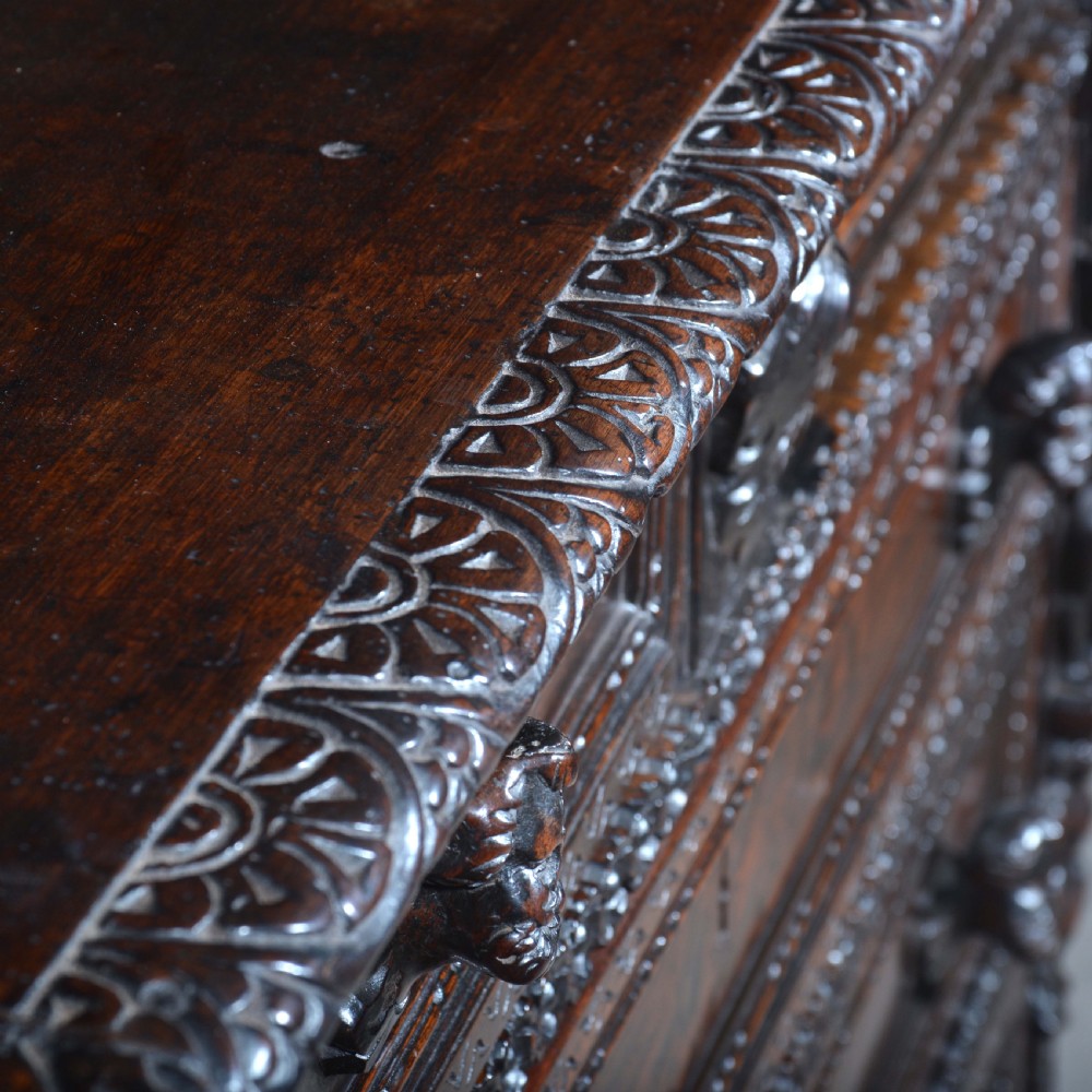 A dark carved walnut Italian Renaissance style chest of drawers featuring small carved figural pilasters and turned bun feet. View XVI