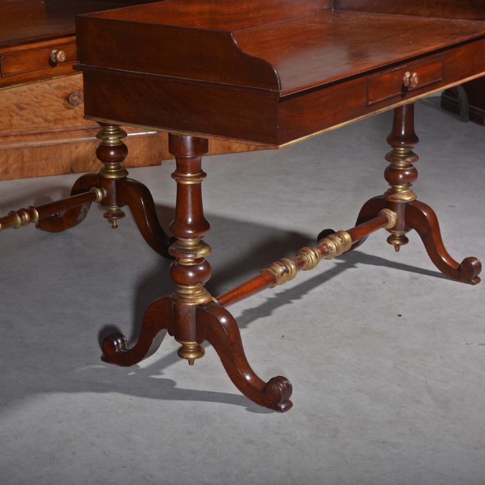 A matched pair of mahogany dressing tables featuring raised gallery tops, single frieze drawers, and turned legs with brass-collared stretchers. View IV