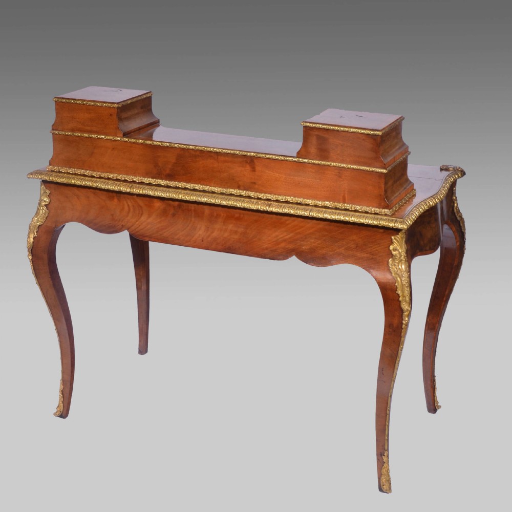 A Louis XV style walnut bureau plat desk featuring a raised superstructure of small drawers, gilt-bronze mounts, floral porcelain plaques, and cabriole legs. View III
