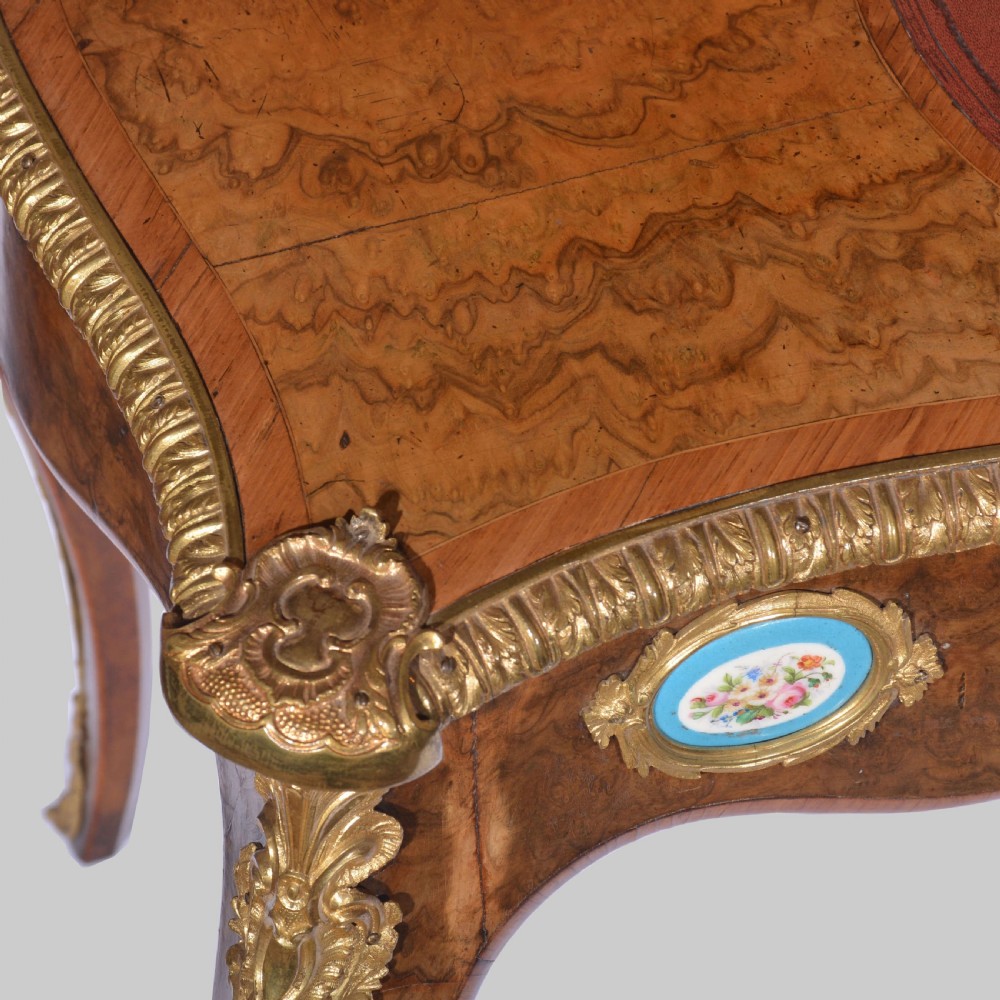 A Louis XV style walnut bureau plat desk featuring a raised superstructure of small drawers, gilt-bronze mounts, floral porcelain plaques, and cabriole legs. View VI