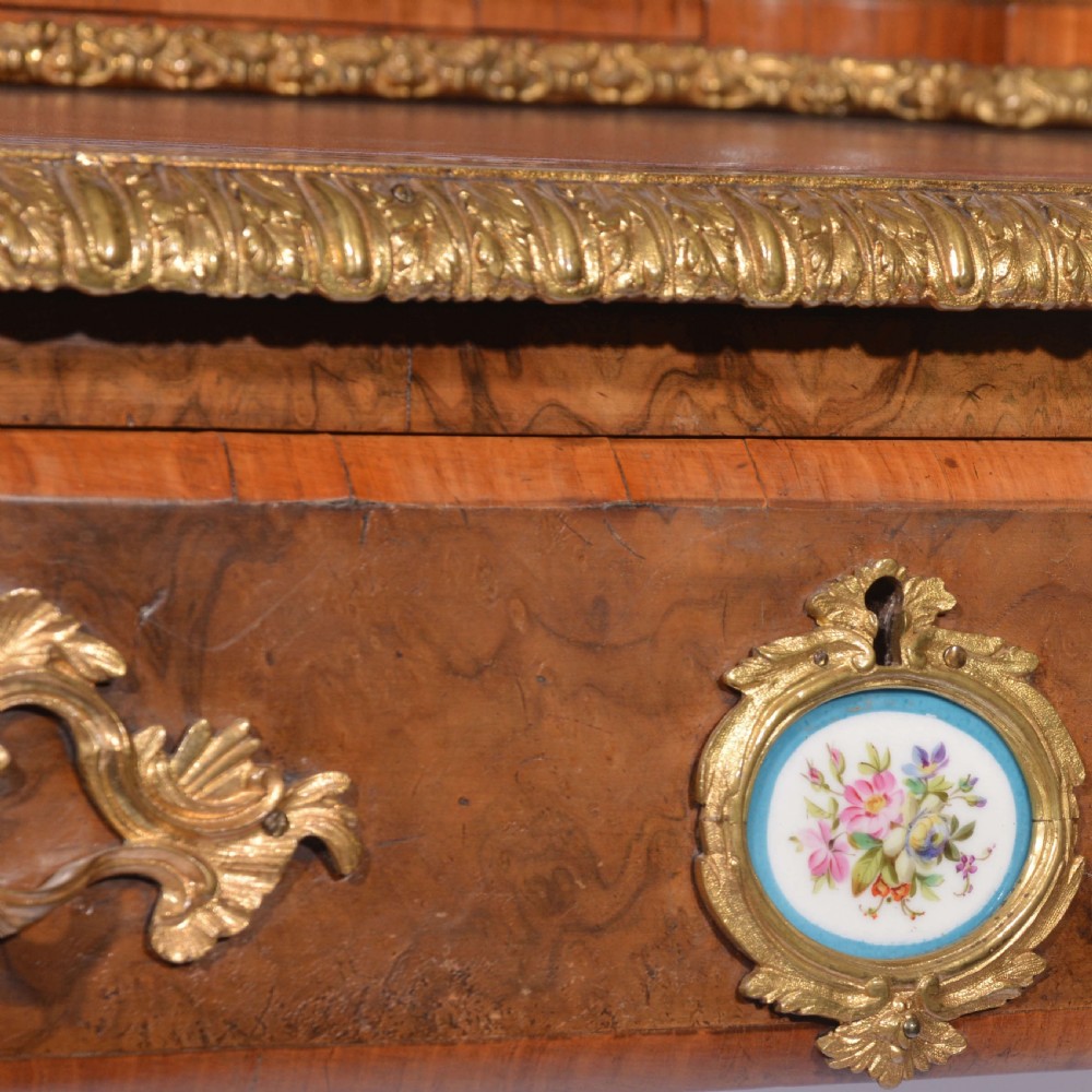 A Louis XV style walnut bureau plat desk featuring a raised superstructure of small drawers, gilt-bronze mounts, floral porcelain plaques, and cabriole legs. View IX