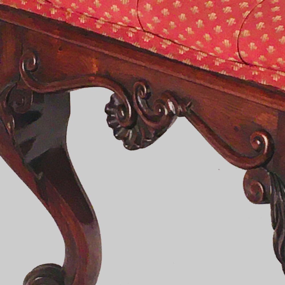 A square antique Anglo-Indian rosewood stool featuring a button-tufted red upholstery seat above intricately carved cabriole legs. View III