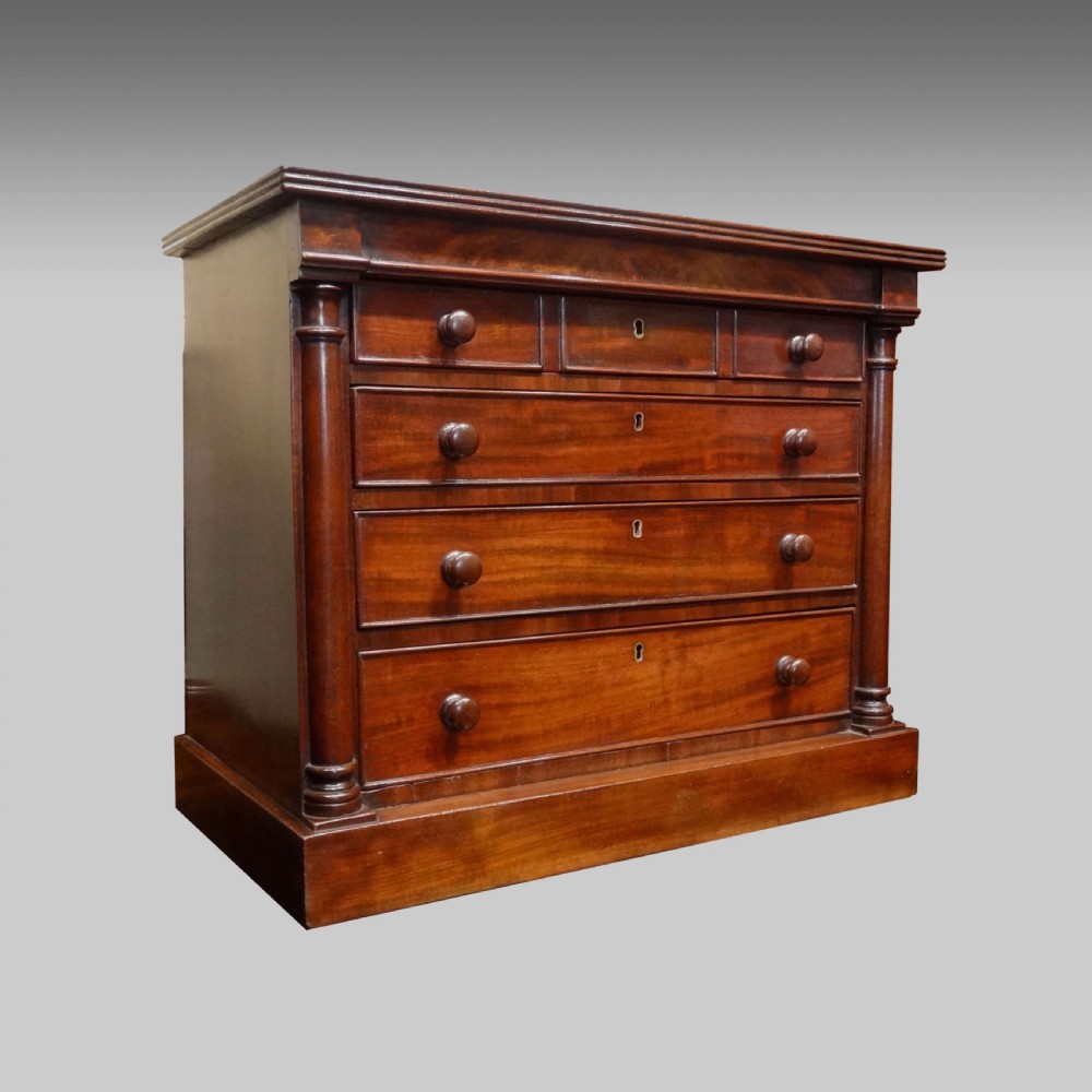 A Regency mahogany miniature chest of drawers with turned side columns, flame mahogany drawer fronts, and small wooden turned handles. View II