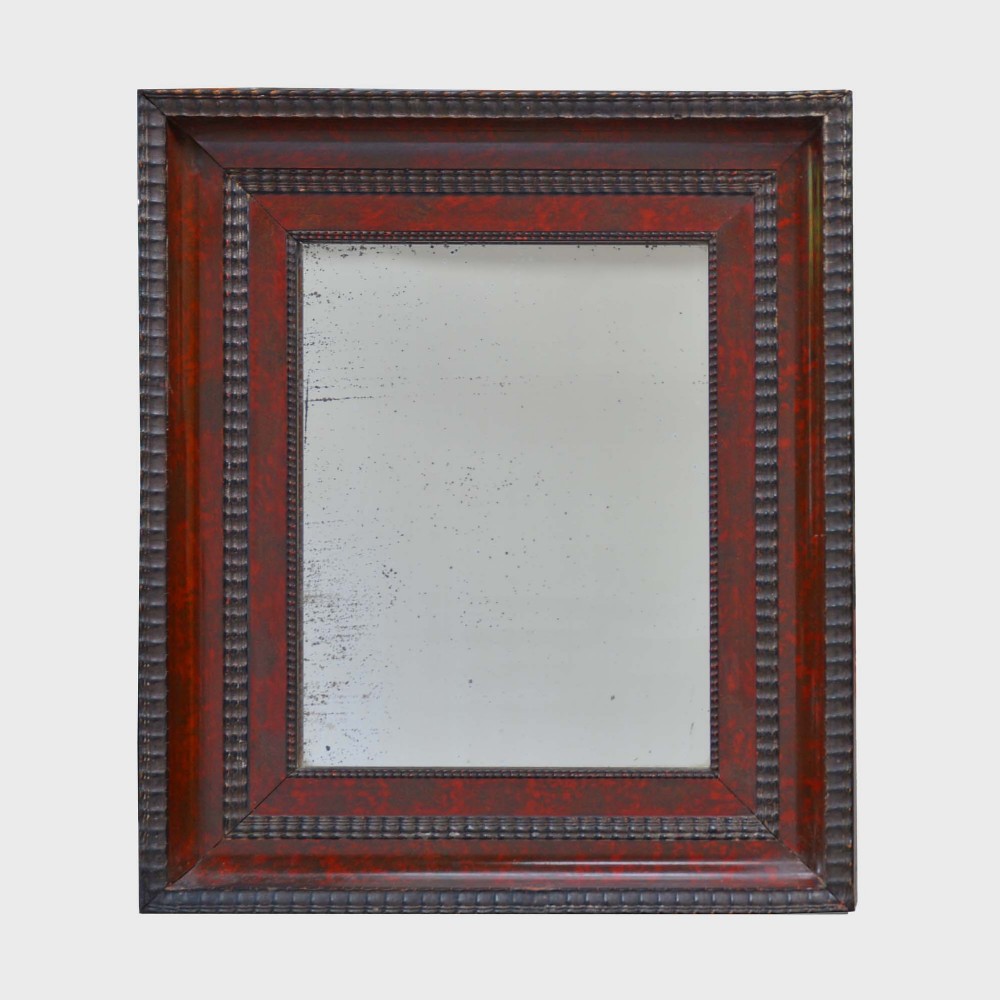 A rectangular Dutch Baroque style wall mirror featuring a deep red tortoiseshell veneer frame with dark ebonised ripple moulding edges and aged mirror glass.