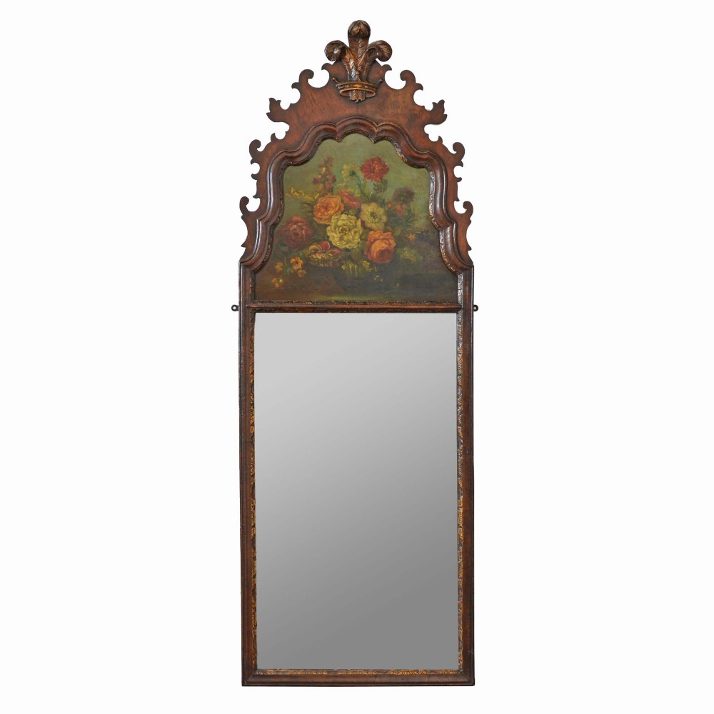 An 18th-century Dutch walnut pier mirror featuring a carved cresting, an upper panel with a floral still-life oil painting, and a tall rectangular glass plate.