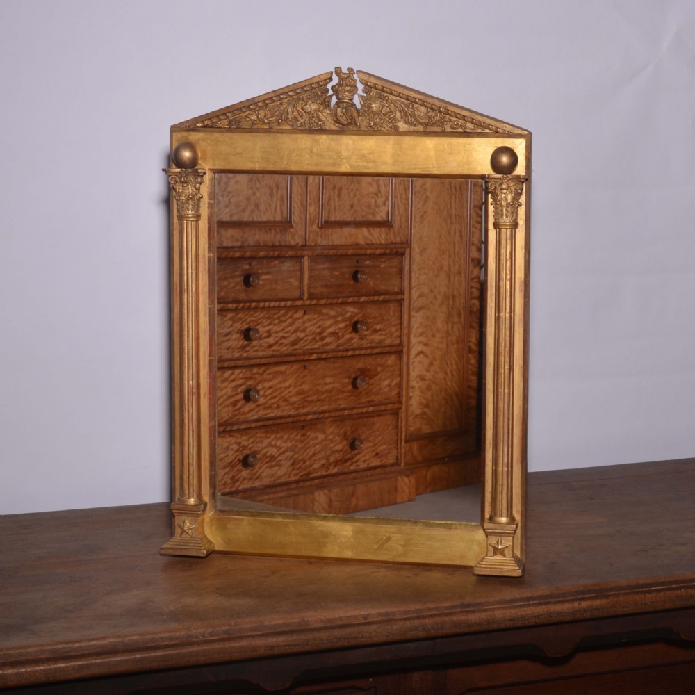 A rectangular 19th-century giltwood wall mirror featuring fluted Corinthian pilasters, a triangular pediment with a carved crest, and gold star details on the base corners. View VII