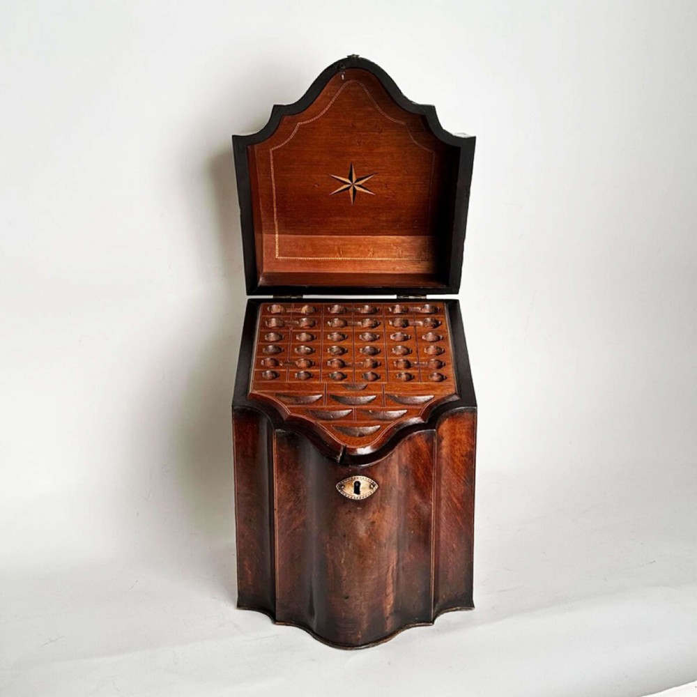 An antique Sheraton mahogany knife box featuring a sloped lid, serpentine shaped front, and a brass keyhole escutcheon. View III