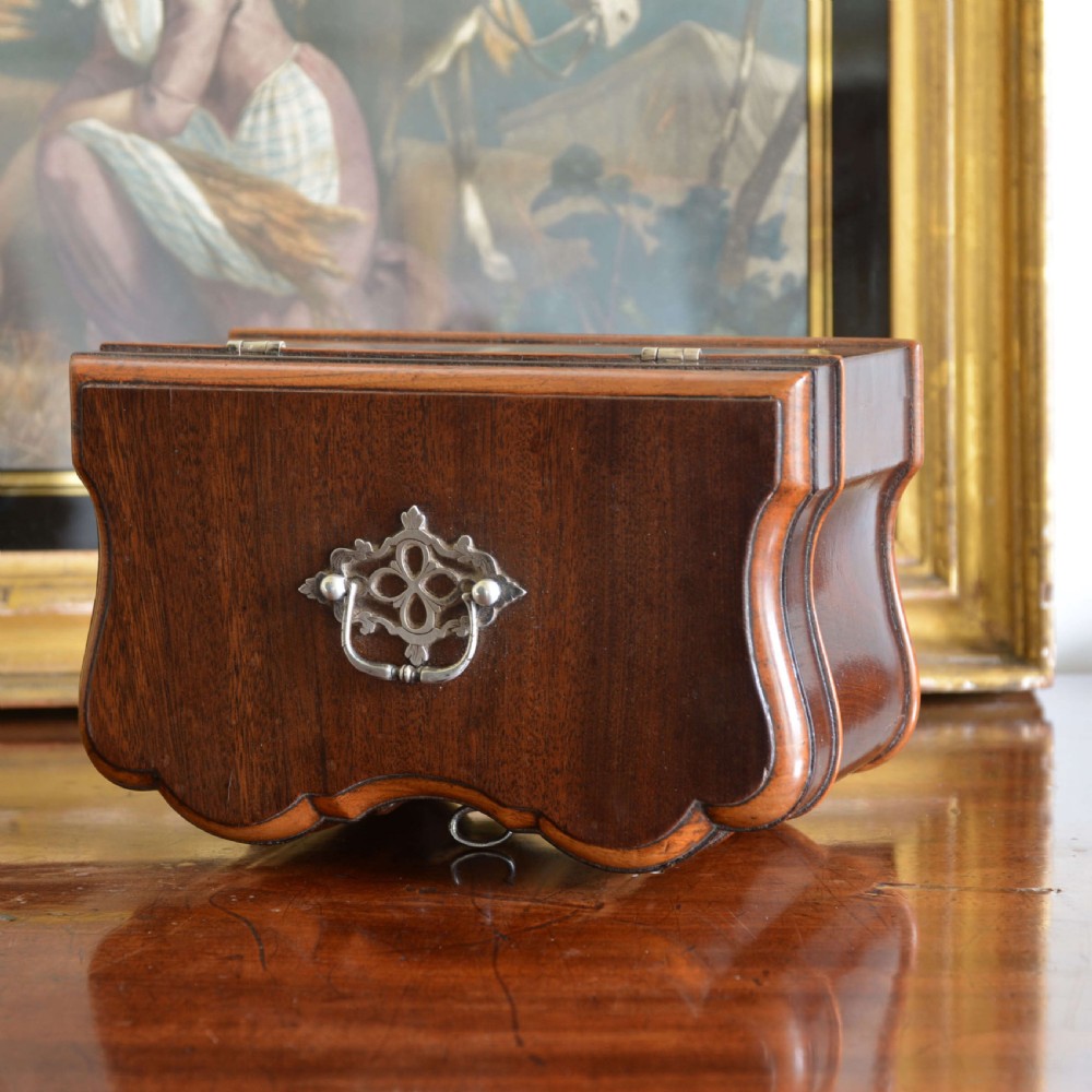 An early 18th-century shaped red walnut tea caddy featuring a top brass handle and a metal escutcheon with a key inserted. View III