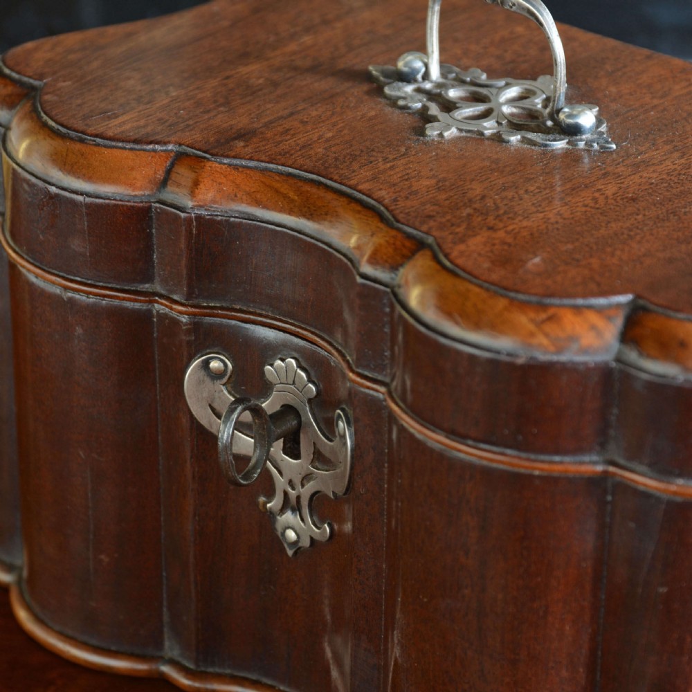 An early 18th-century shaped red walnut tea caddy featuring a top brass handle and a metal escutcheon with a key inserted. View IV