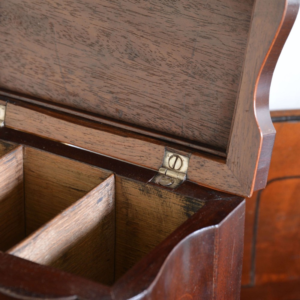 An early 18th-century shaped red walnut tea caddy featuring a top brass handle and a metal escutcheon with a key inserted. View VII