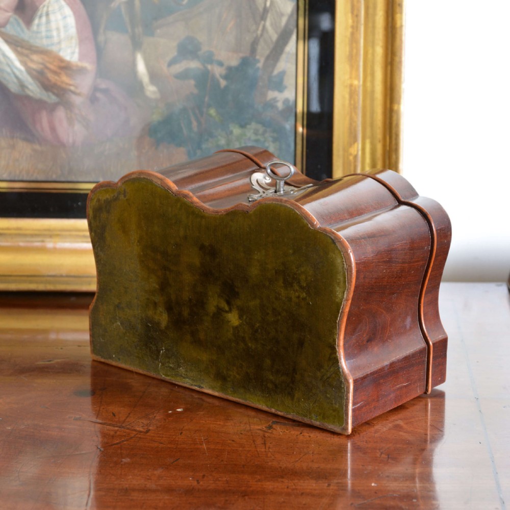 An early 18th-century shaped red walnut tea caddy featuring a top brass handle and a metal escutcheon with a key inserted. View VIII