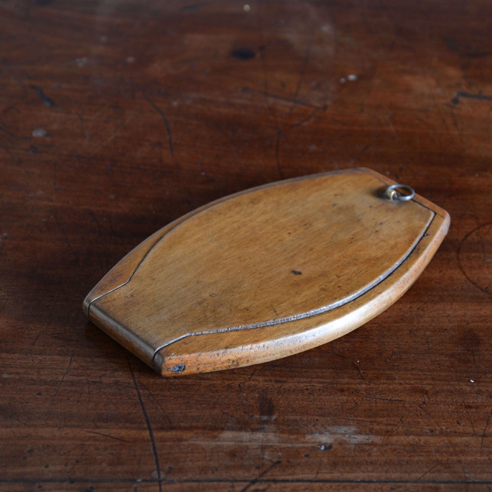 A hinged walnut campaign shaving mirror with an oval glass plate resting open on a wooden surface. View VII