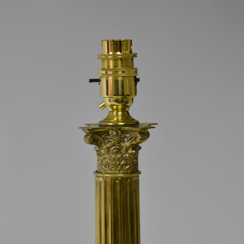 A Victorian cast brass table lamp featuring a fluted Corinthian column shaft topped with acanthus leaves on a stepped plinth. View III