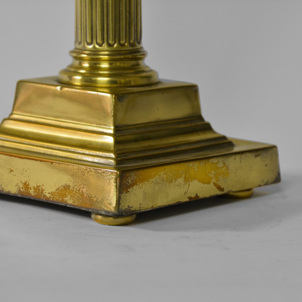 A Victorian cast brass table lamp featuring a fluted Corinthian column shaft topped with acanthus leaves on a stepped plinth. View IV