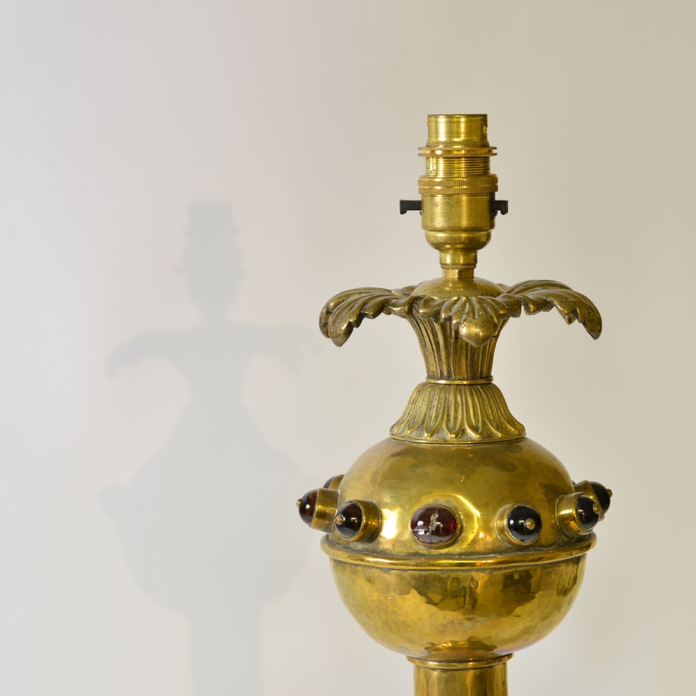 An ornate brass table lamp crafted in a French Gothic style featuring a scrollwork base, turned column, and a central spherical knop set with dark red cabochon accents. View II