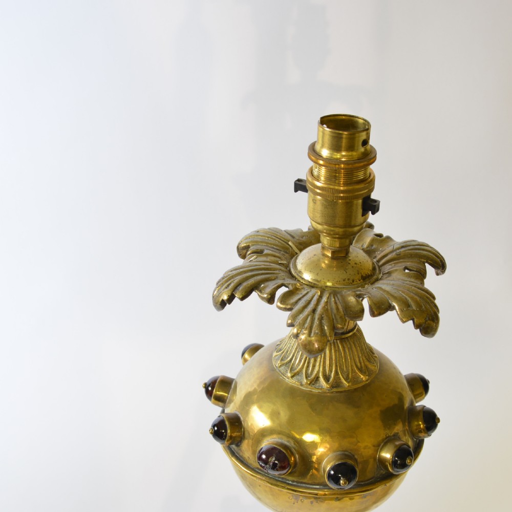 An ornate brass table lamp crafted in a French Gothic style featuring a scrollwork base, turned column, and a central spherical knop set with dark red cabochon accents. View IV