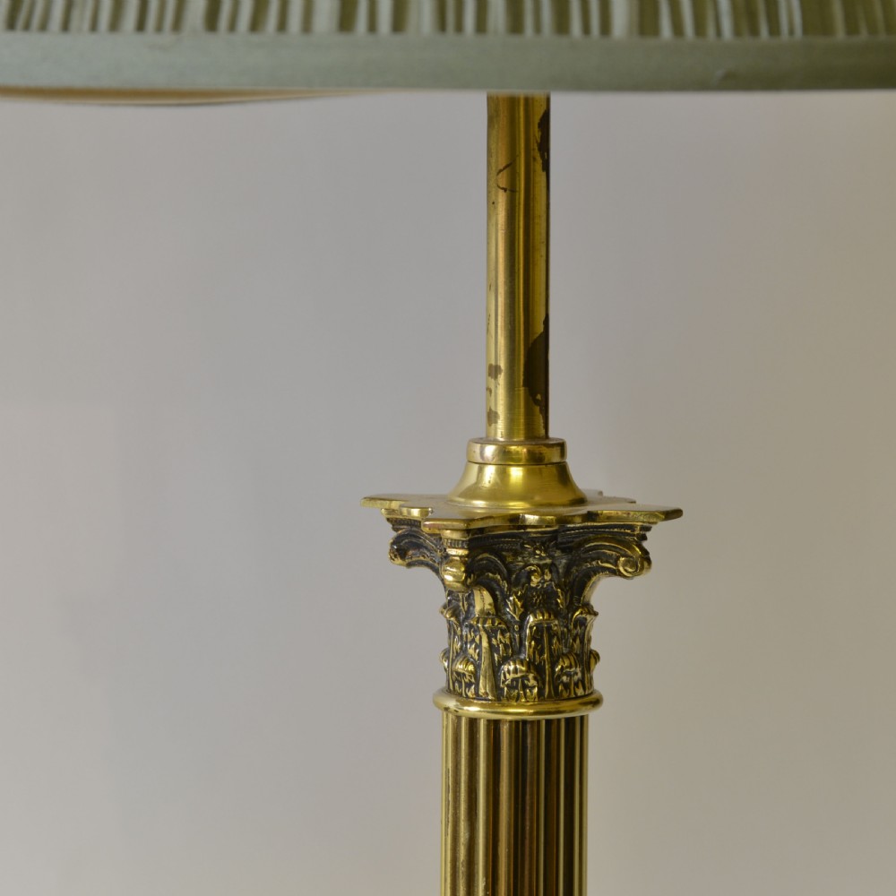 A Victorian brass table lamp designed as a fluted Corinthian column with a stepped base, topped with a pleated sage green fabric shade. View III