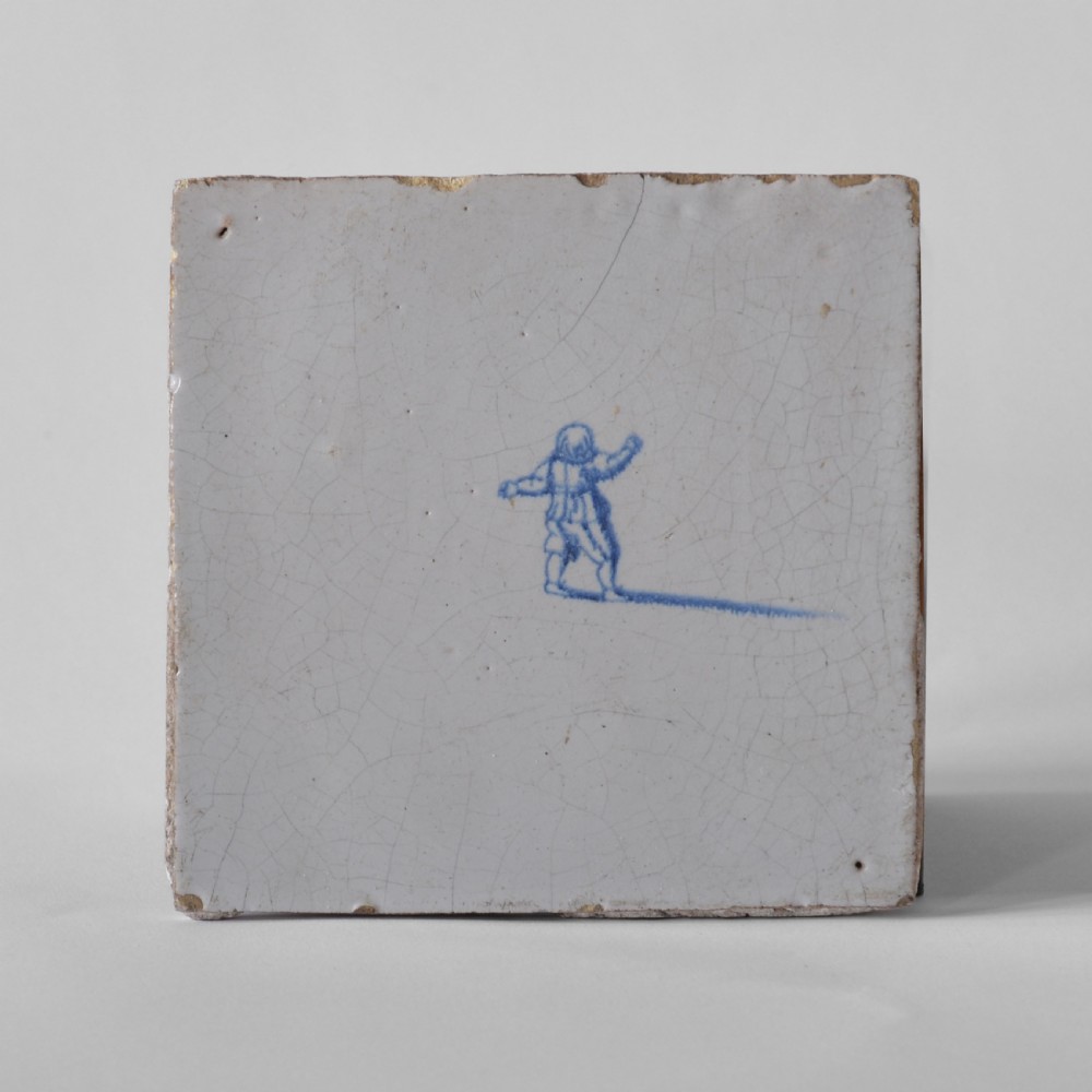 Square 18th century tin-glazed earthenware tile with hand-painted cobalt blue figure on an off-white surface. View II