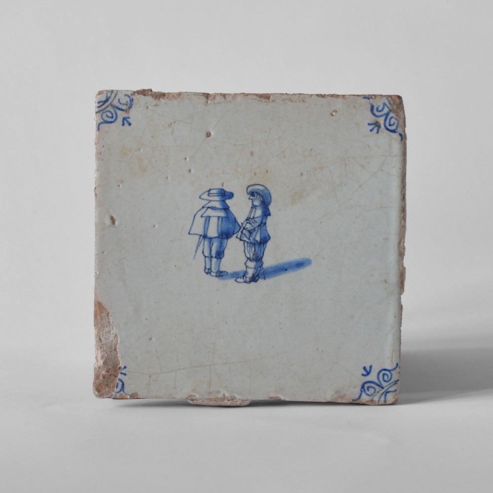 A square 18th-century Dutch Delft tile featuring hand-painted figures in cobalt blue on a crazed off-white tin-glazed earthenware surface with corner embellishments. View II