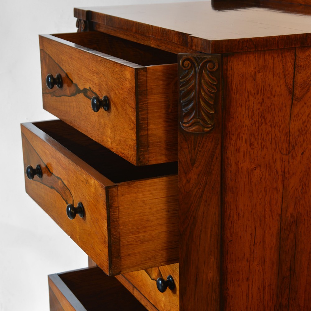 A 19th-century rosewood Wellington chest featuring six graduated drawers, turned wooden knobs, carved corbels, and a side-locking bar on a plinth base. View IV