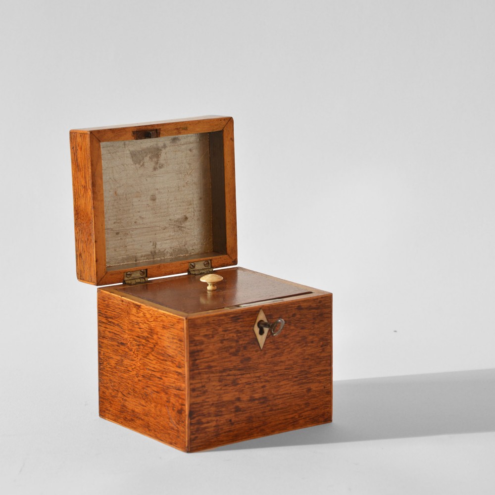 A cubic Georgian mahogany tea caddy featuring boxwood edge stringing, a diamond bone escutcheon, and an iron key. View II