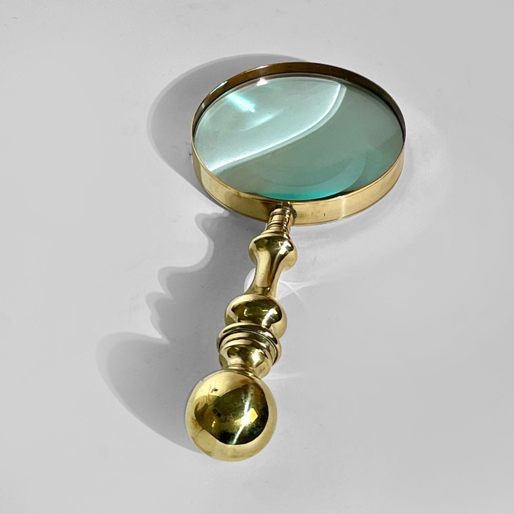 A 19th-century brass magnifying glass featuring a turned handle with a spherical finial and a circular convex lens. View IV