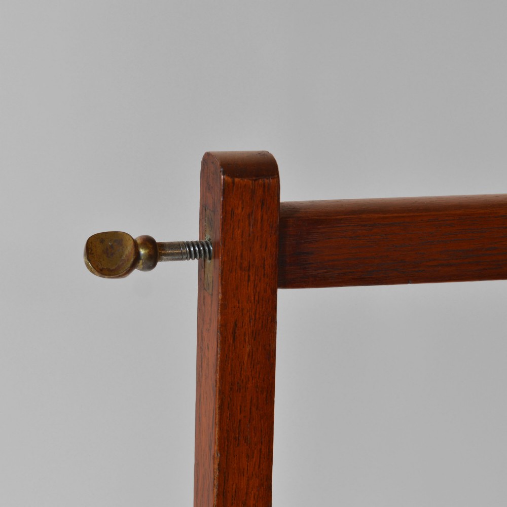 A 19th-century freestanding teak campaign towel rail featuring three horizontal bars, brass fittings, and splayed trestle feet against a plain background. View II