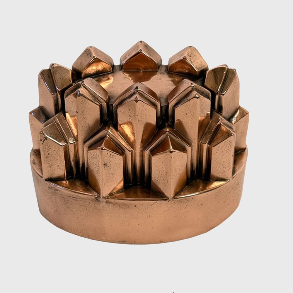 A 19th-century oval copper jelly mould featuring tiered, pointed geometric facets and a polished finish.