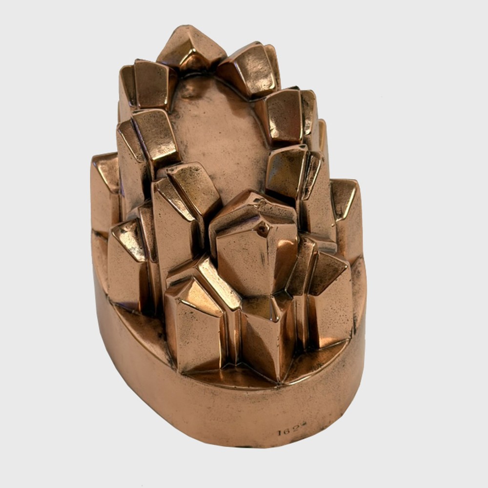 A 19th-century oval copper jelly mould featuring tiered, pointed geometric facets and a polished finish. View II