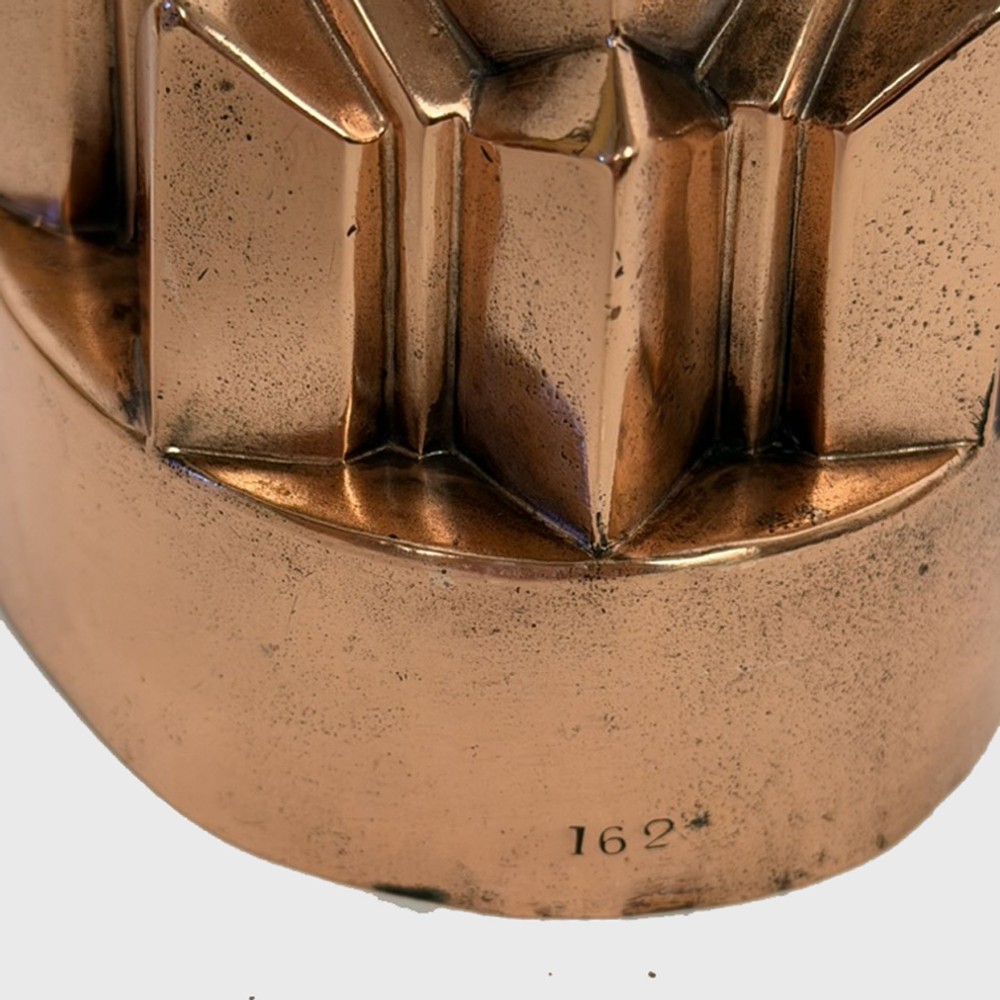A 19th-century oval copper jelly mould featuring tiered, pointed geometric facets and a polished finish. View III
