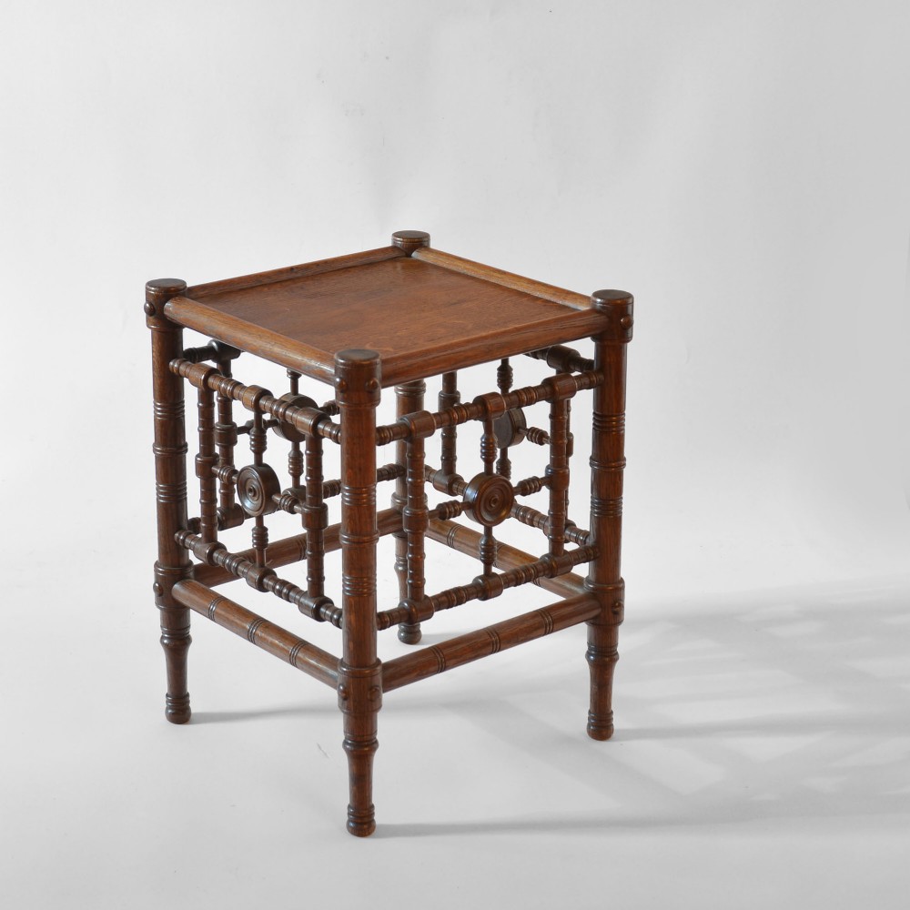 A late nineteenth-century oak side table designed in the Aesthetic Movement style with turned spindle sides and carved roundels. View II