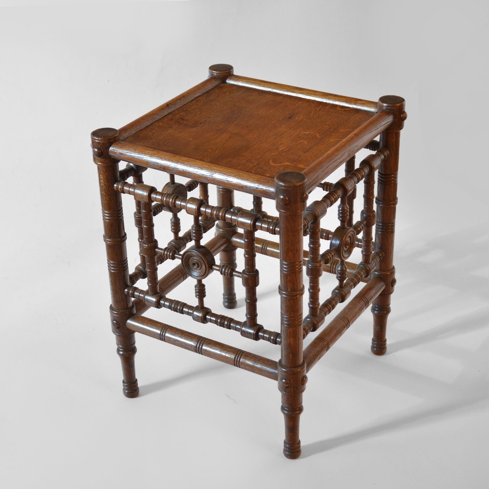 A late nineteenth-century oak side table designed in the Aesthetic Movement style with turned spindle sides and carved roundels. View III