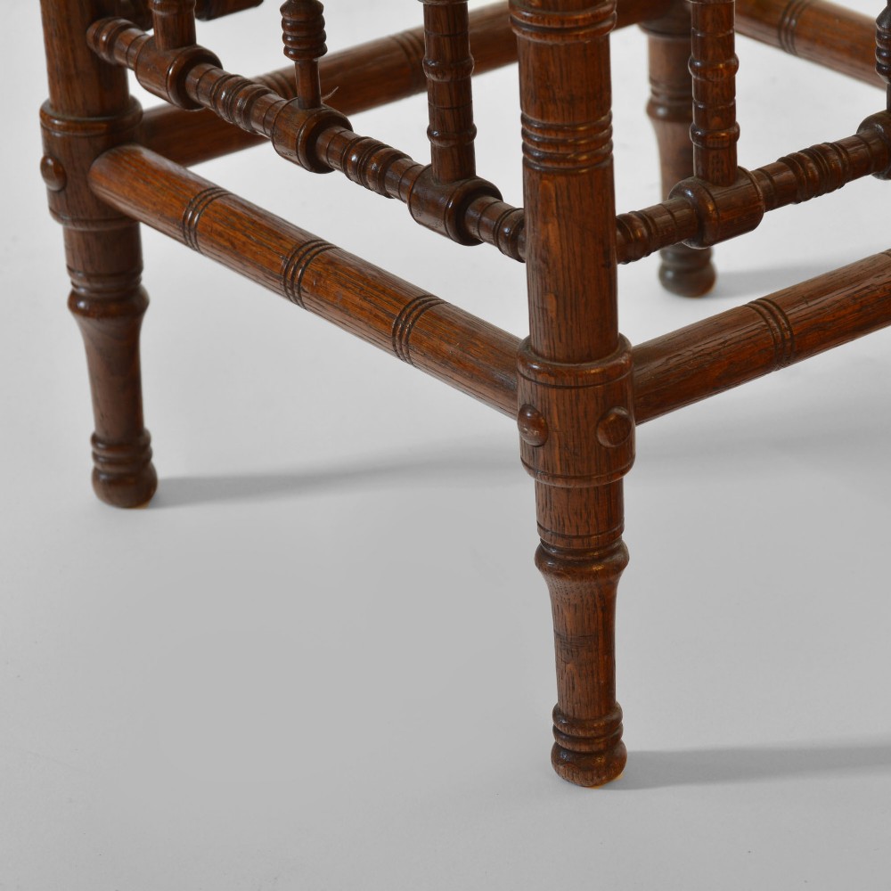 A late nineteenth-century oak side table designed in the Aesthetic Movement style with turned spindle sides and carved roundels. View V