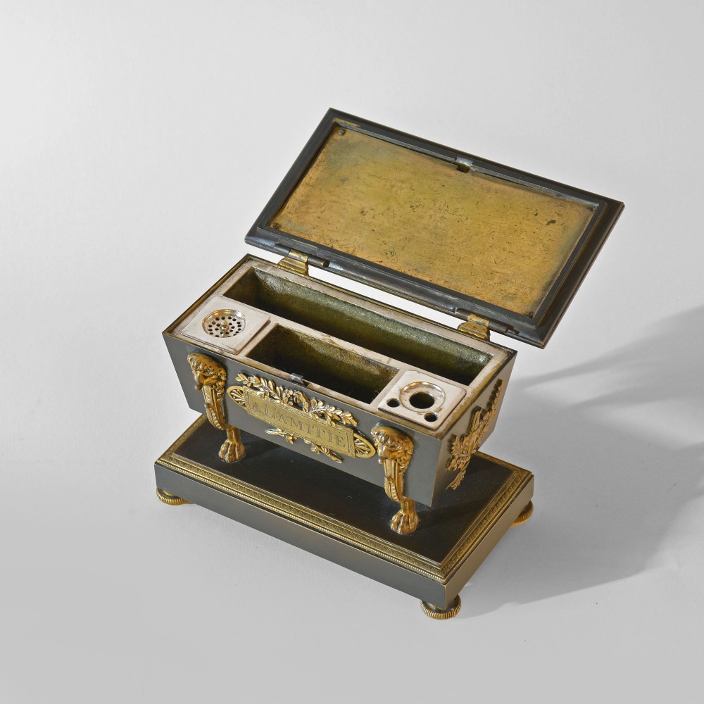 An 18th-century French Directoire casket-form inkstand in patinated black metal and gilt bronze, supported on lion monopodia legs with a inscribed plaque. View IV