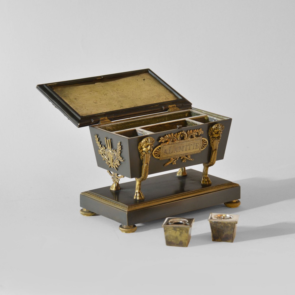 An 18th-century French Directoire casket-form inkstand in patinated black metal and gilt bronze, supported on lion monopodia legs with a inscribed plaque. View V