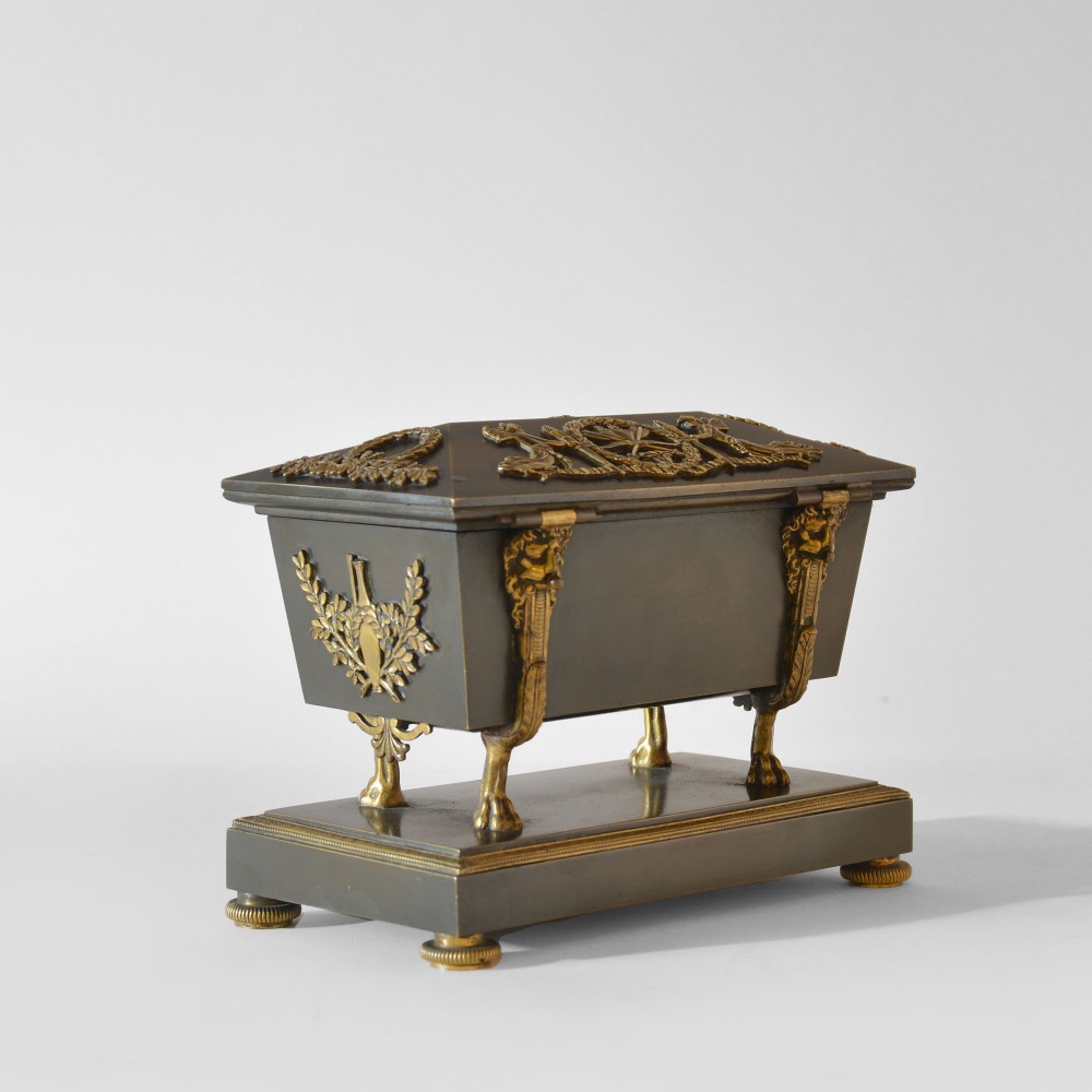 An 18th-century French Directoire casket-form inkstand in patinated black metal and gilt bronze, supported on lion monopodia legs with a inscribed plaque. View VI