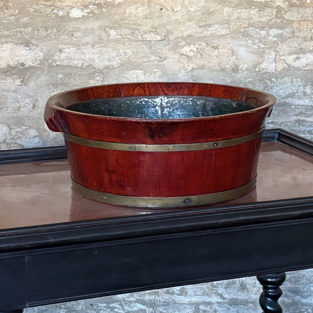 An oval 19th-century mahogany coopered jardiniere featuring horizontal brass binding bands and integrated wooden handles. View IV