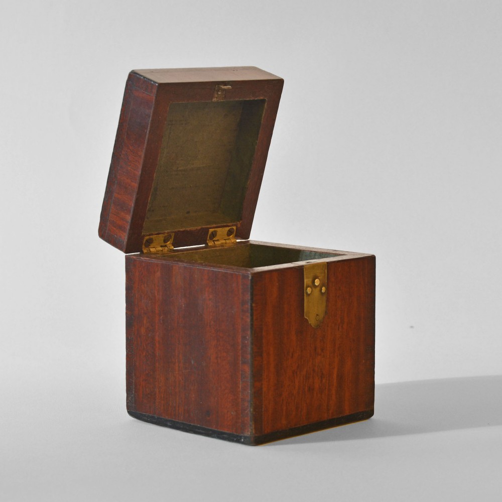 A cubic Georgian mahogany tea caddy featuring a brass loop handle on the top lid and a brass latch on the front. View II