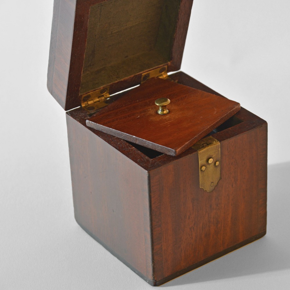 A cubic Georgian mahogany tea caddy featuring a brass loop handle on the top lid and a brass latch on the front. View III