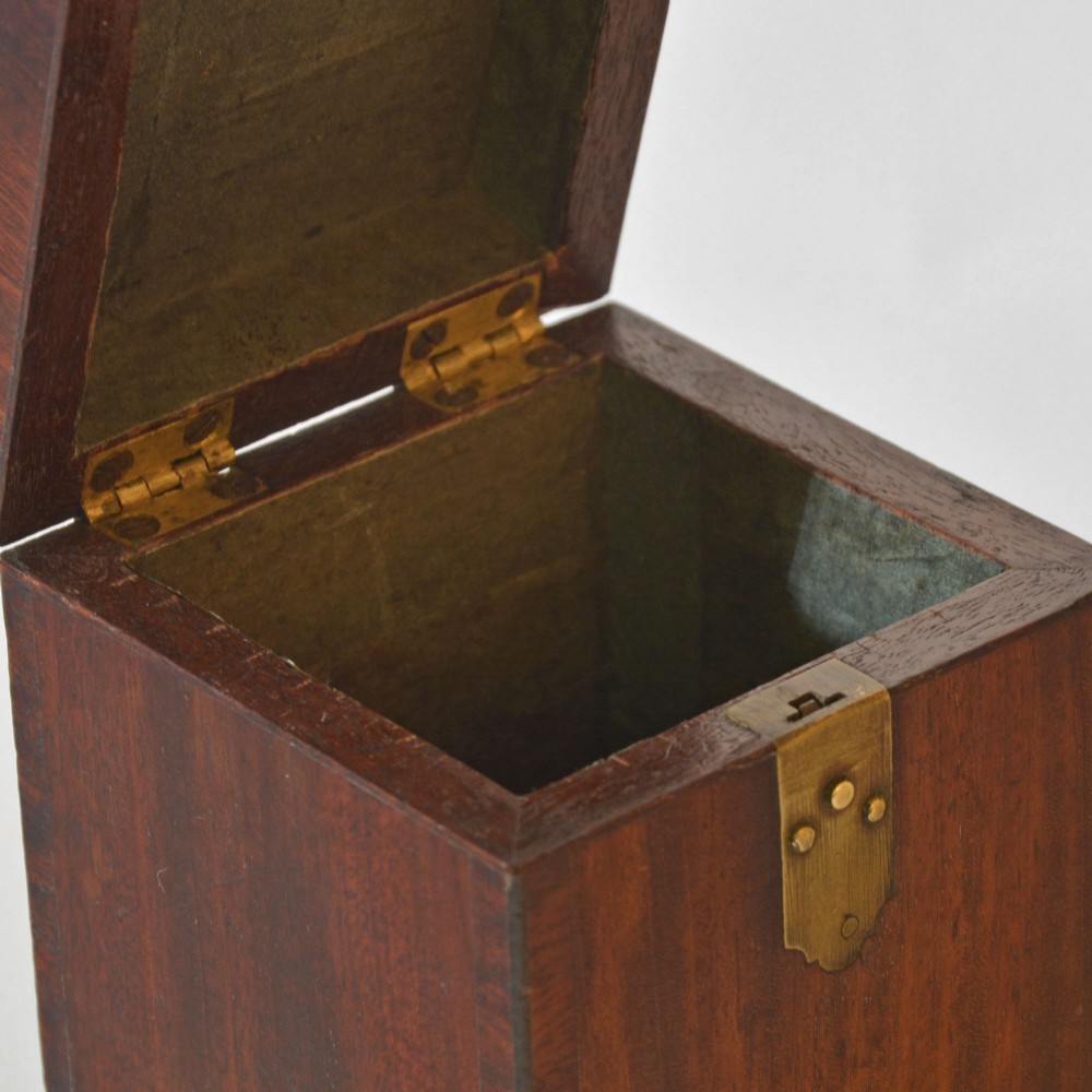 A cubic Georgian mahogany tea caddy featuring a brass loop handle on the top lid and a brass latch on the front. View IV
