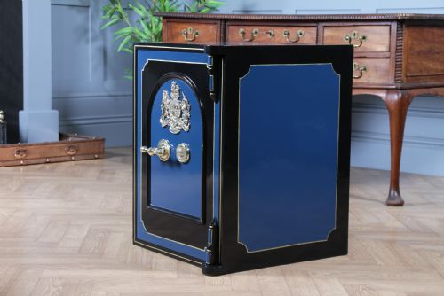 fig 7. A heavy restored Victorian cast iron safe featuring a deep blue and black lacquered exterior with gold pinstriping and a brass royal coat of arms crest.
