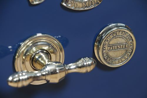 fig 8. A heavy restored Victorian cast iron safe featuring a deep blue and black lacquered exterior with gold pinstriping and a brass royal coat of arms crest.