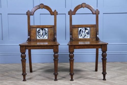 fig 3. A pair of Victorian Arts and Crafts solid oak hall chairs featuring arched backrests inset with monochrome ceramic Minton tiles and turned front legs.