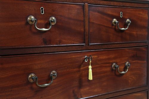 fig 3. An eighteenth-century Georgian mahogany chest of drawers featuring four drawers with brass swan-neck handles and bracket feet.