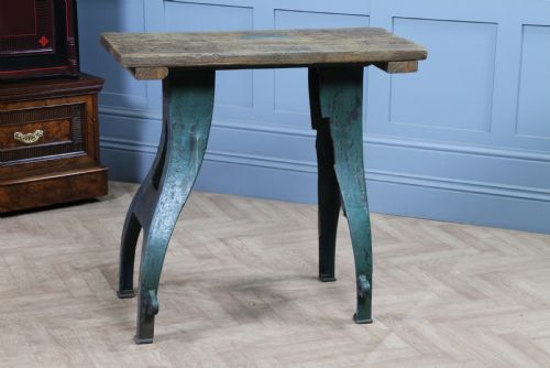 fig 1. An industrial console table featuring distressed blue painted cast iron machinery legs supporting a rectangular reclaimed pine top.