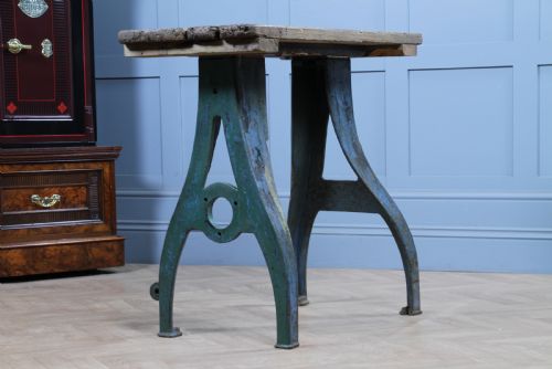 fig 2. An industrial console table featuring distressed blue painted cast iron machinery legs supporting a rectangular reclaimed pine top.