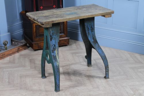 fig 3. An industrial console table featuring distressed blue painted cast iron machinery legs supporting a rectangular reclaimed pine top.