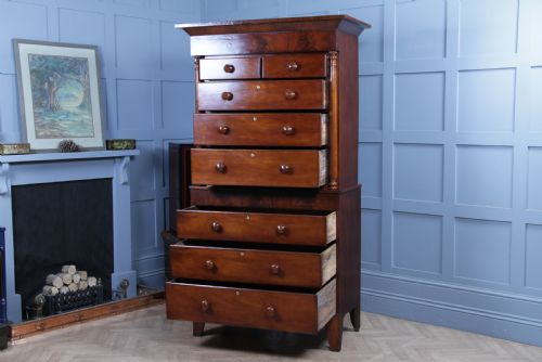 fig 3. A Georgian Scottish mahogany chest on chest featuring eight drawers with turned wooden knobs, fluted side columns, and an overhanging pediment cornice.