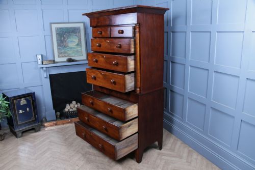 fig 4. A Georgian Scottish mahogany chest on chest featuring eight drawers with turned wooden knobs, fluted side columns, and an overhanging pediment cornice.